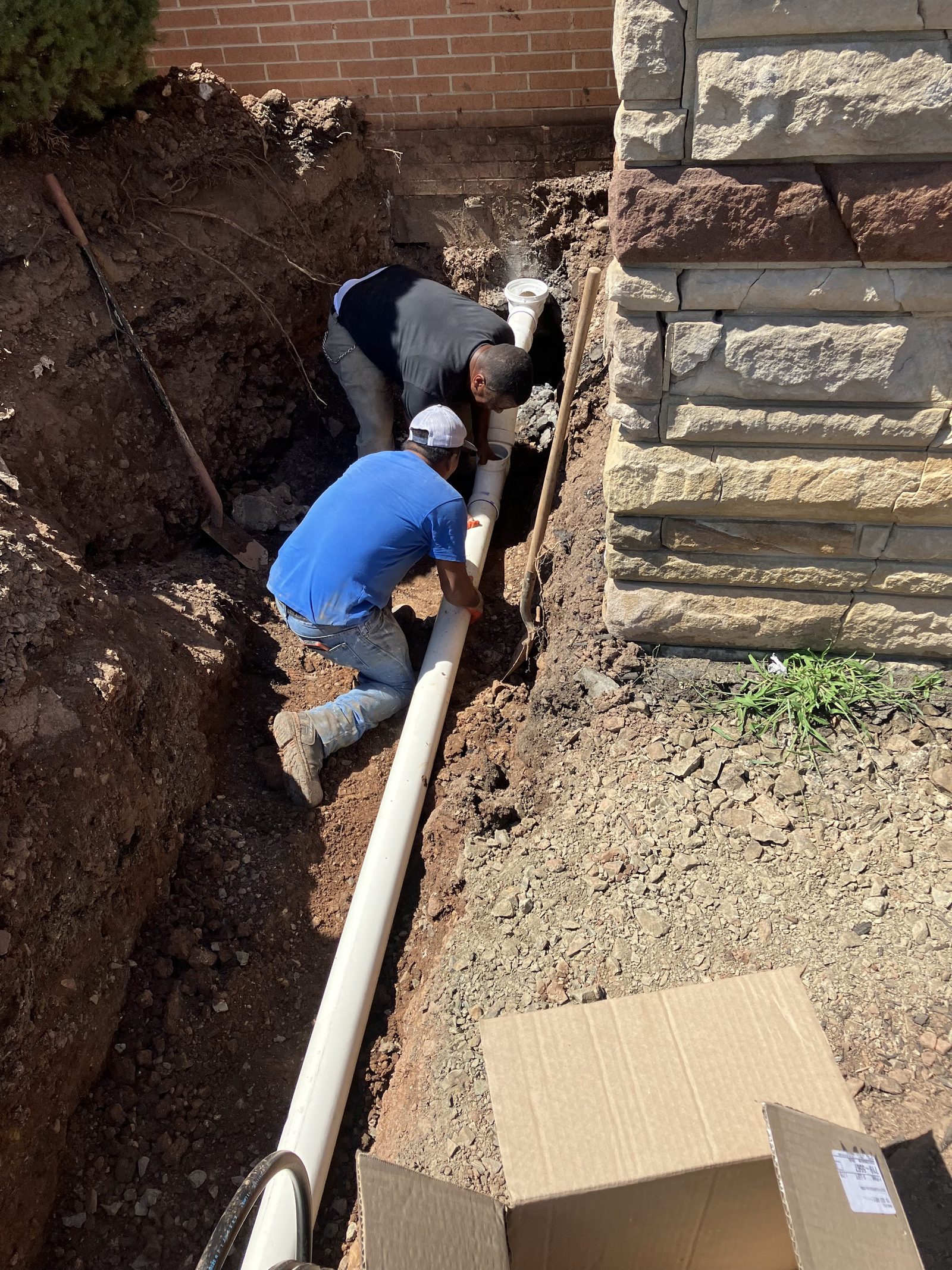 Heights crew replacing a sewer line by excavation next to a home foundation in New Jersey