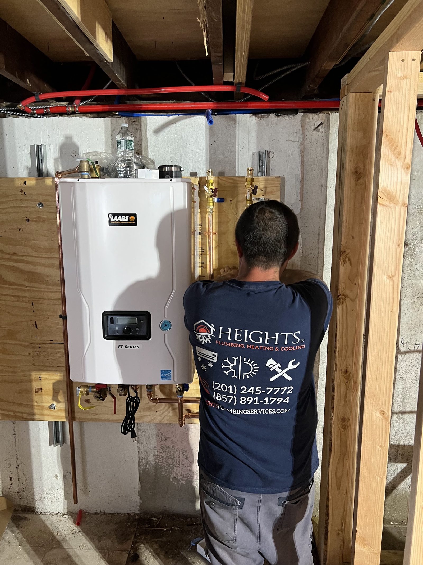 Heights Plumbing, Heating & Cooling technician installing a wall-hung tankless water heater in a New Jersey home