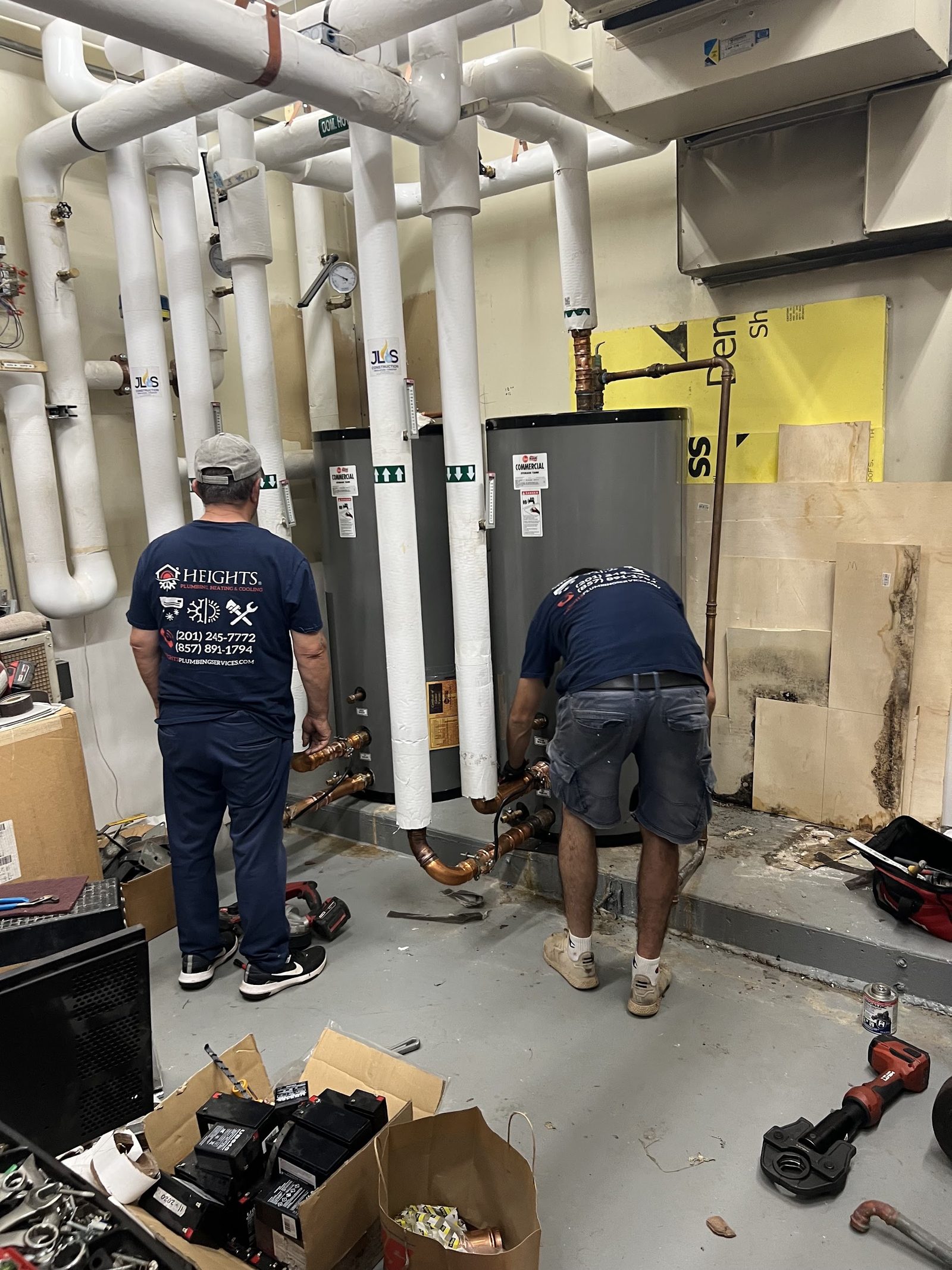 Heights technicians piping commercial water heaters in a boiler room in New Jersey