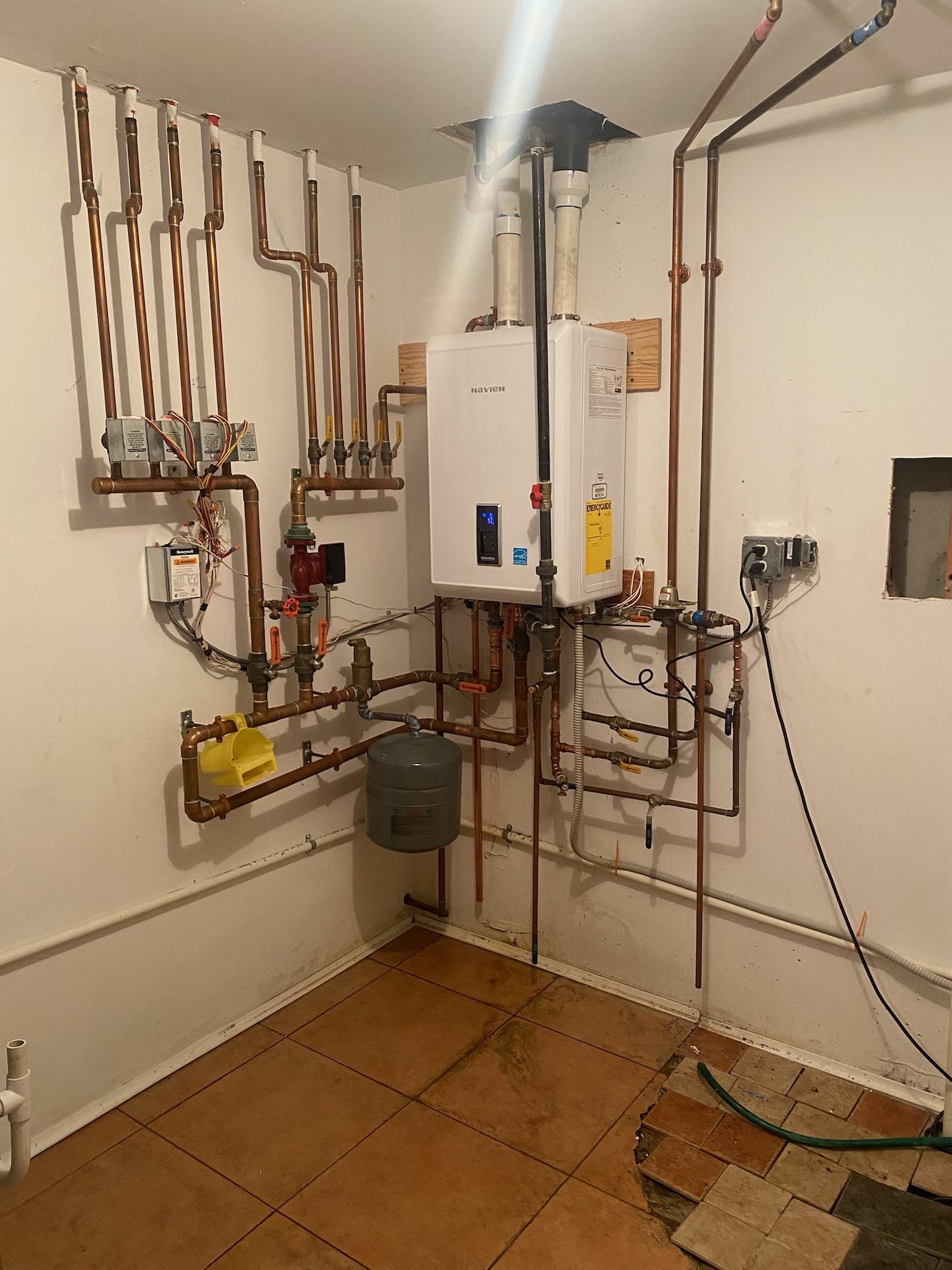 Tankless water heater with clean copper piping installed in a New Jersey utility room